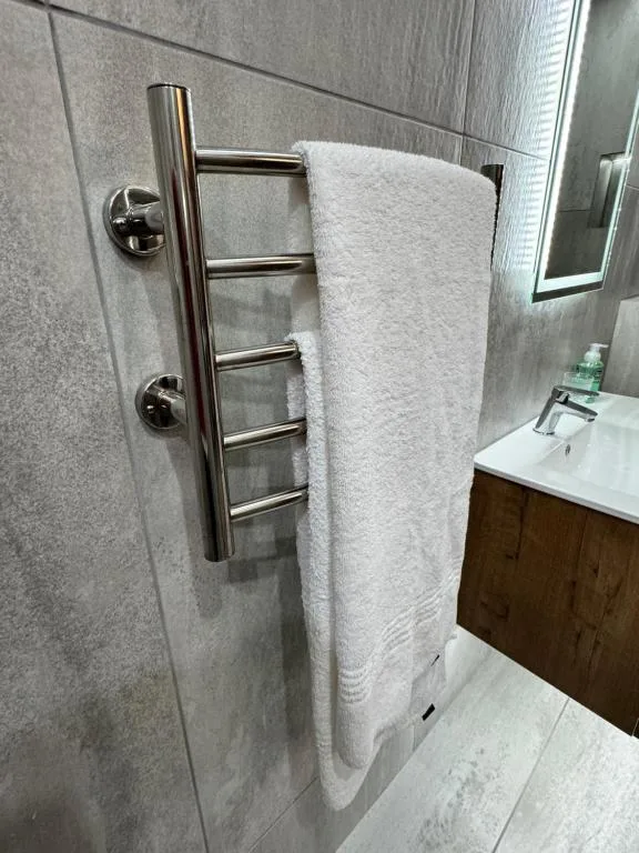Modern bathroom with heated towel rack and white fluffy towel displayed