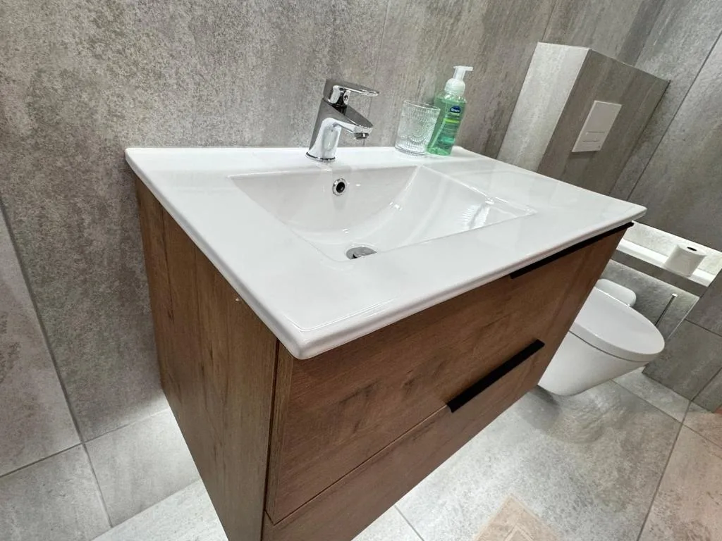Modern bathroom vanity with white ceramic sink and chrome tap