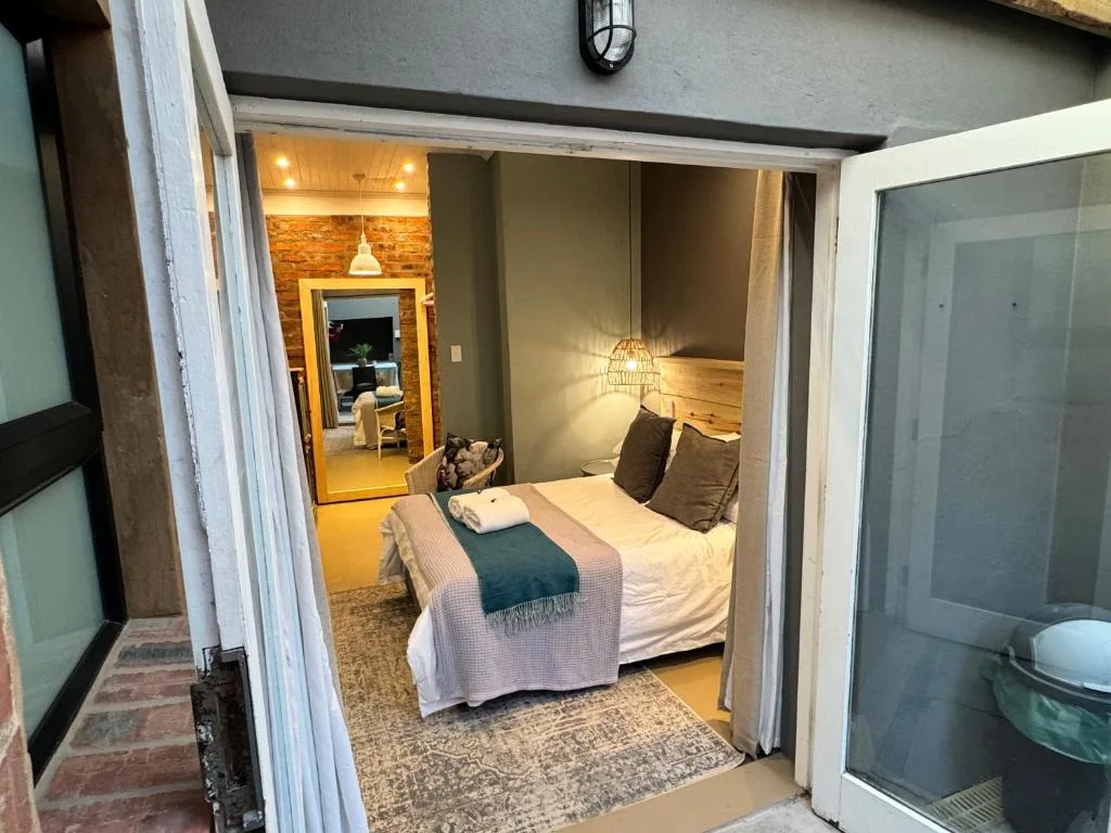 Cozy bedroom with double bed, brown pillows, and warm pendant lighting