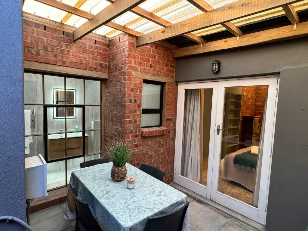 Covered outdoor patio with dining table and skylight panels overhead