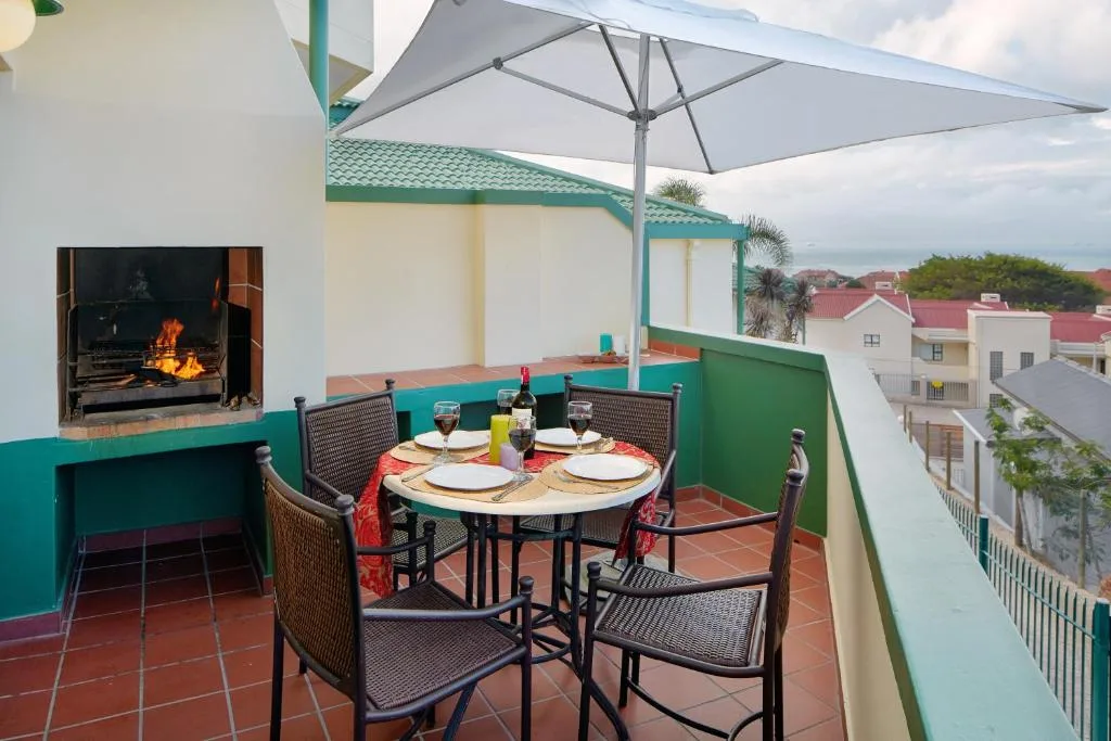 Rooftop terrace with dining table, fireplace, and town views