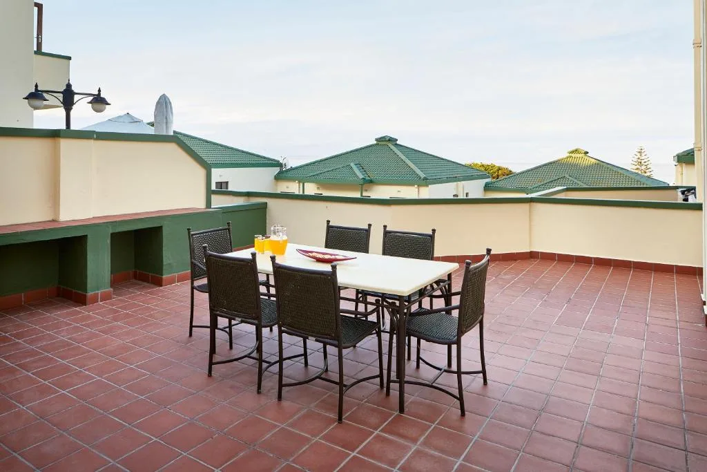 Rooftop terrace with dining table and chairs overlooking town