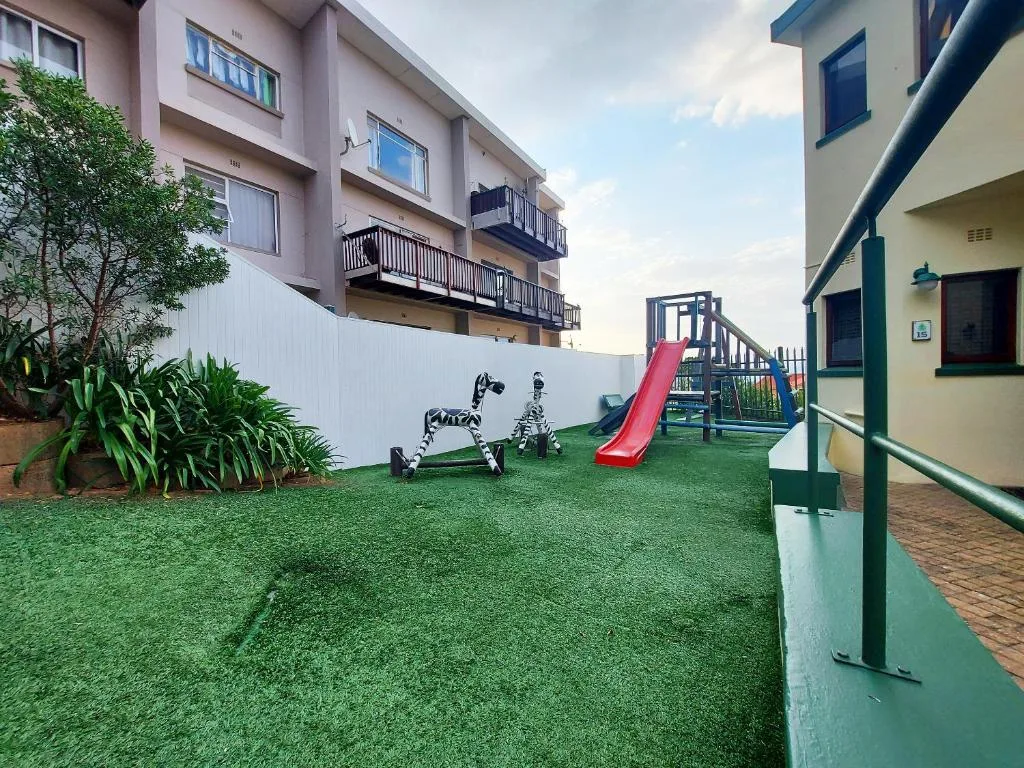 Children's play area with slide and toys in landscaped garden courtyard