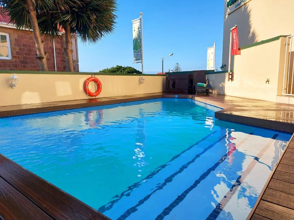 Clear blue swimming pool with lane markers and wooden deck surround