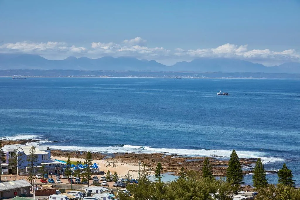 Panoramic ocean and mountain vista from coastal property overlooking beach