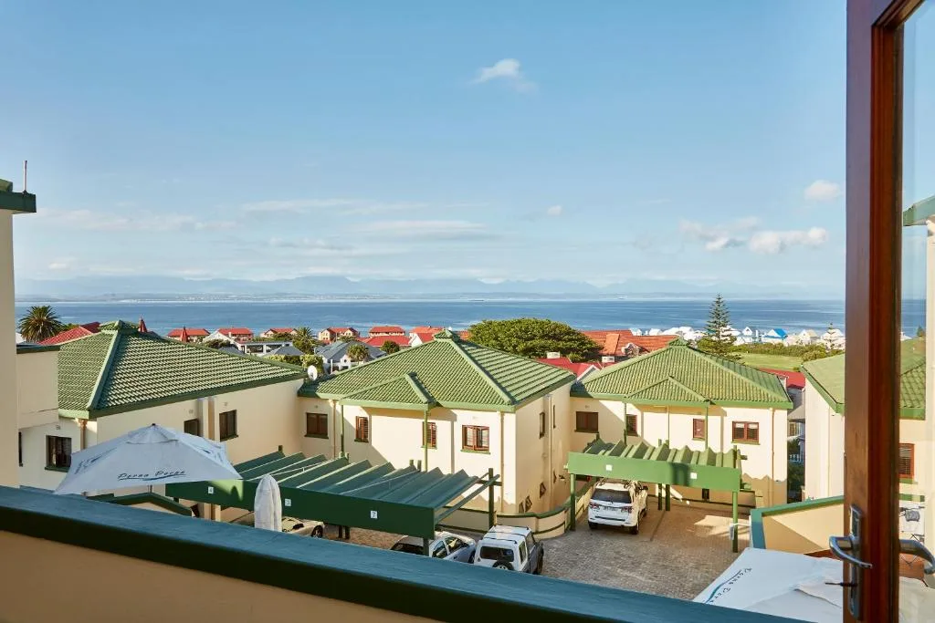 Scenic coastal view of Mossel Bay with ocean, mountains, and neighboring properties