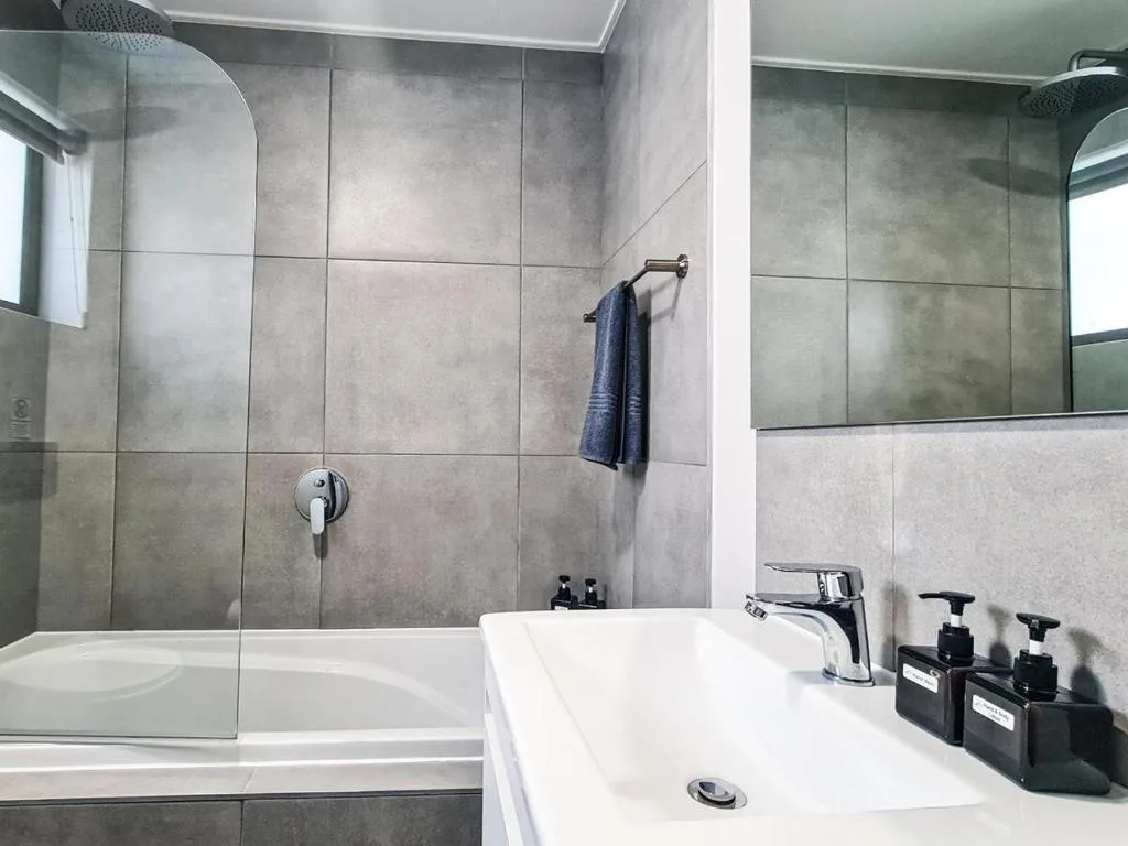 Modern bathroom with tiled shower enclosure and white vanity sink