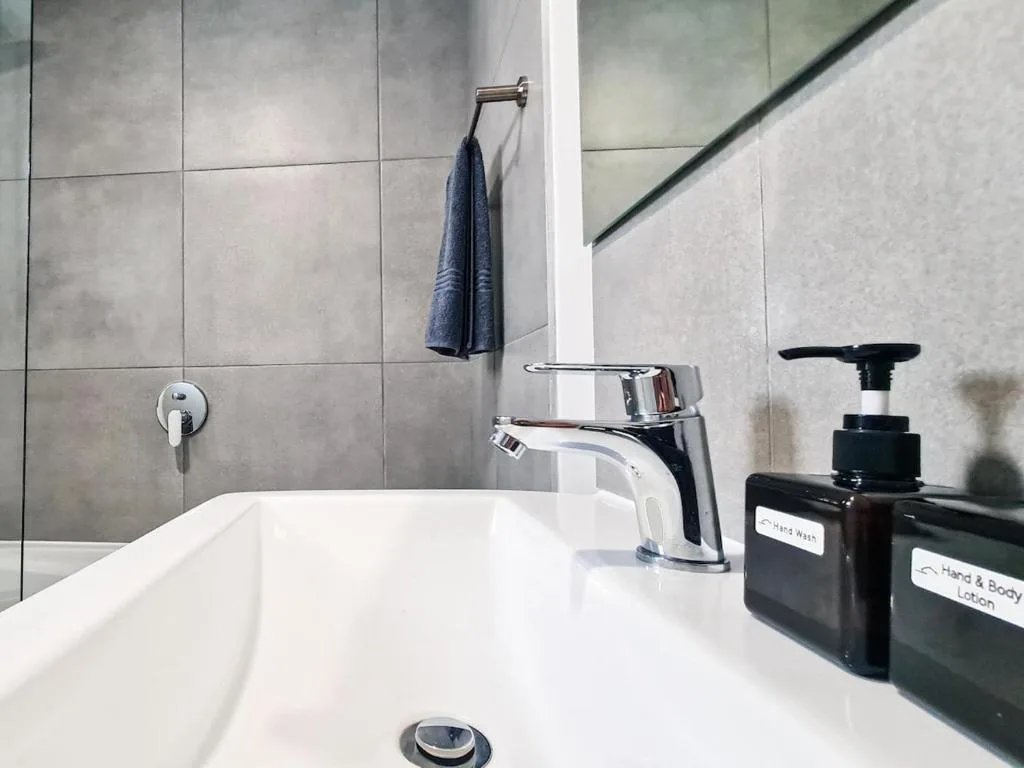 Modern bathroom vanity with chrome faucet and amenities