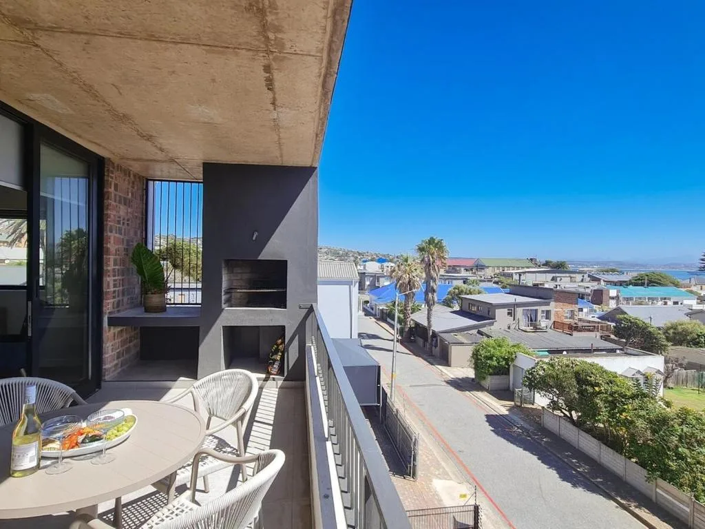 Spacious outdoor deck with dining table overlooking coastal town and lagoon