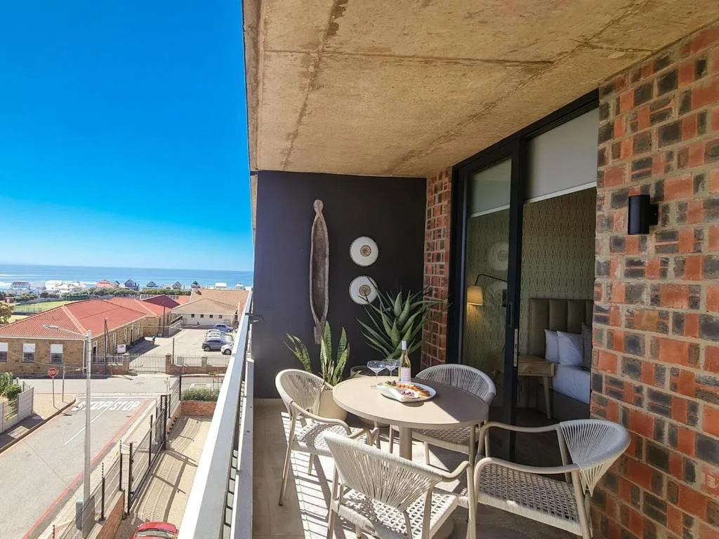Balcony with dining table, chairs, and ocean view beyond