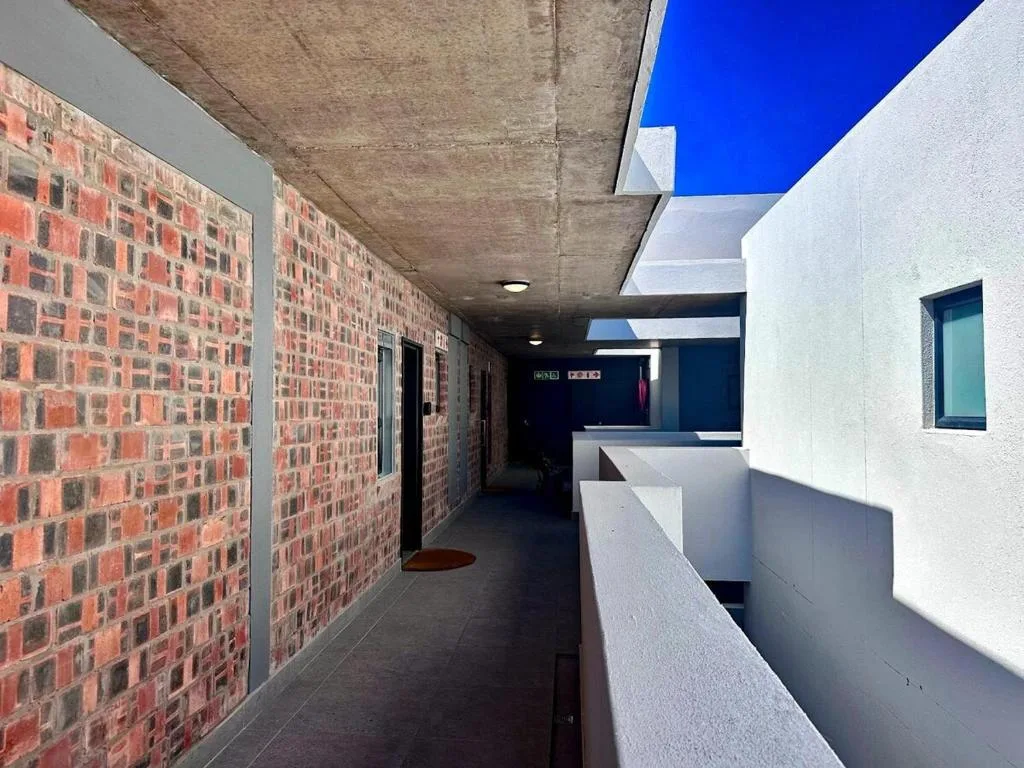 Modern interior hallway with exposed brick walls and skylight openings