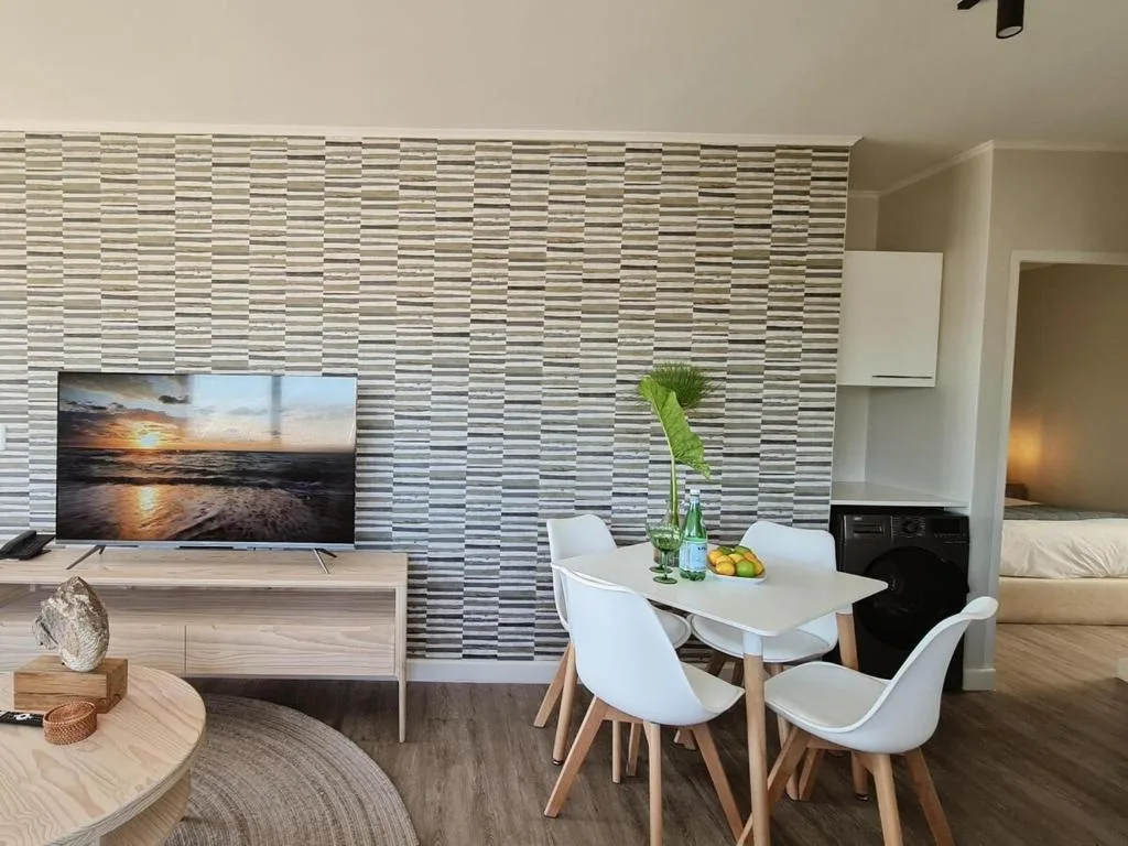 Modern lounge with TV, dining table, and contemporary striped accent wall