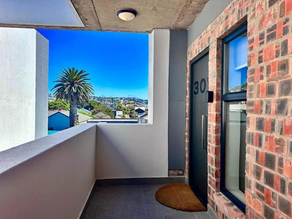 Scenic coastal town view with palm tree through modern window frame