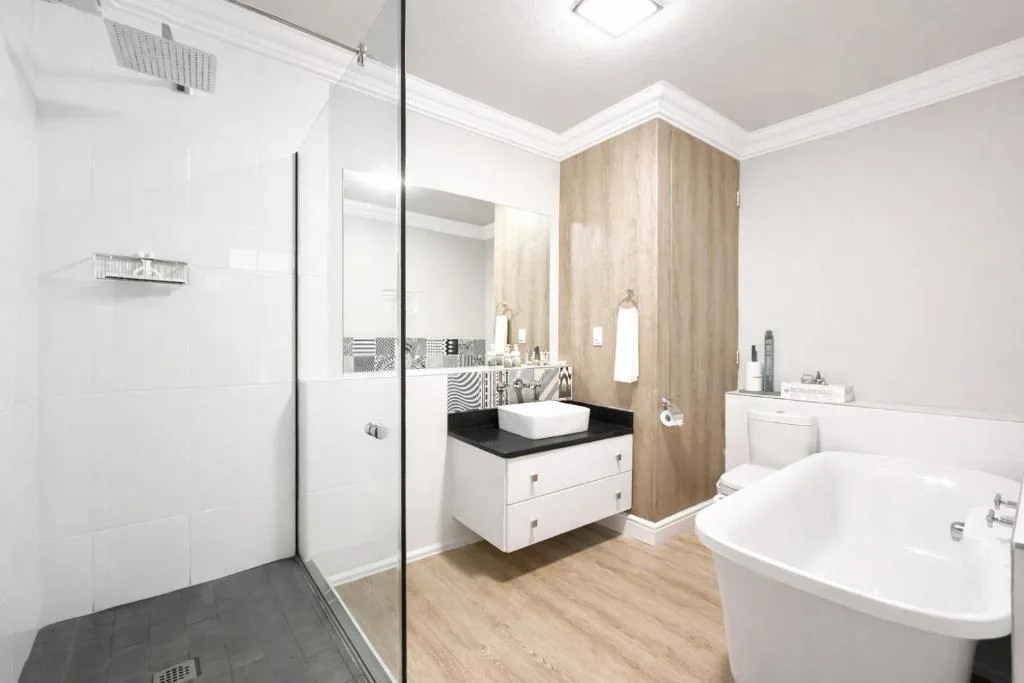 Modern bathroom with walk-in shower, white vanity, and freestanding tub