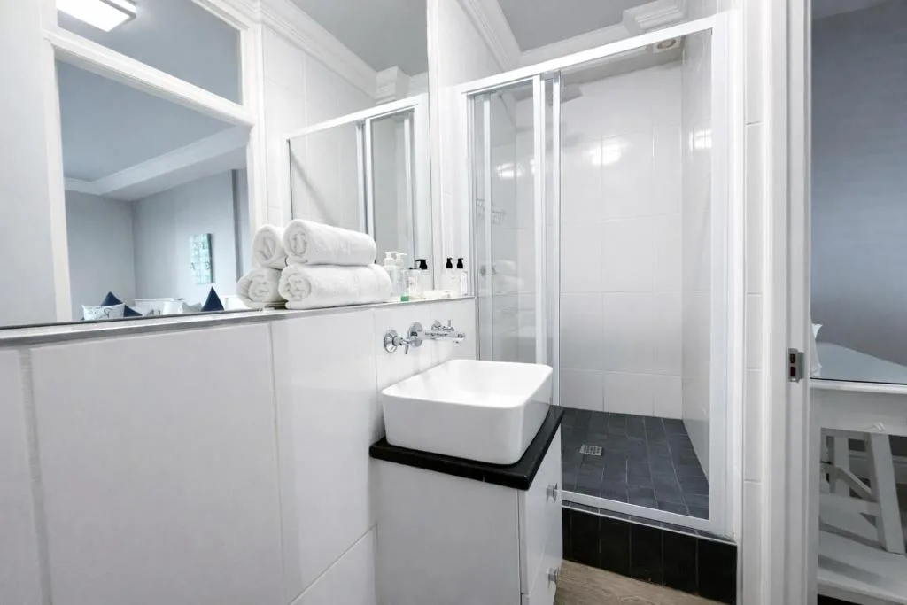 Modern bathroom with white vanity, vessel sink, and spacious shower enclosure