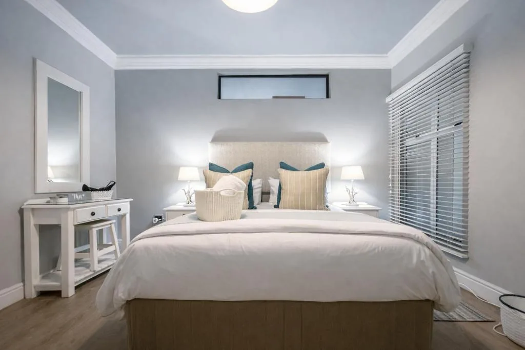 Modern bedroom with queen bed, neutral bedding, and elegant furnishings