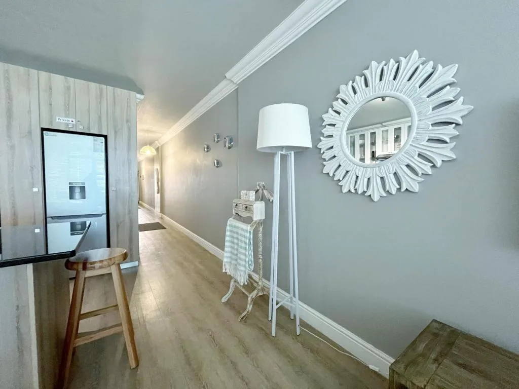 Modern hallway with decorative sunburst mirror and contemporary floor lamp