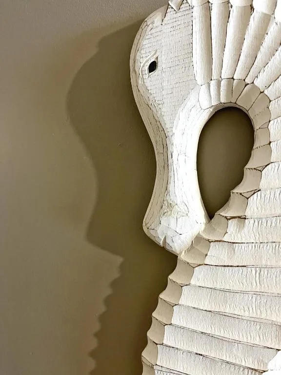 Whitewashed wooden ostrich head wall sculpture with decorative details