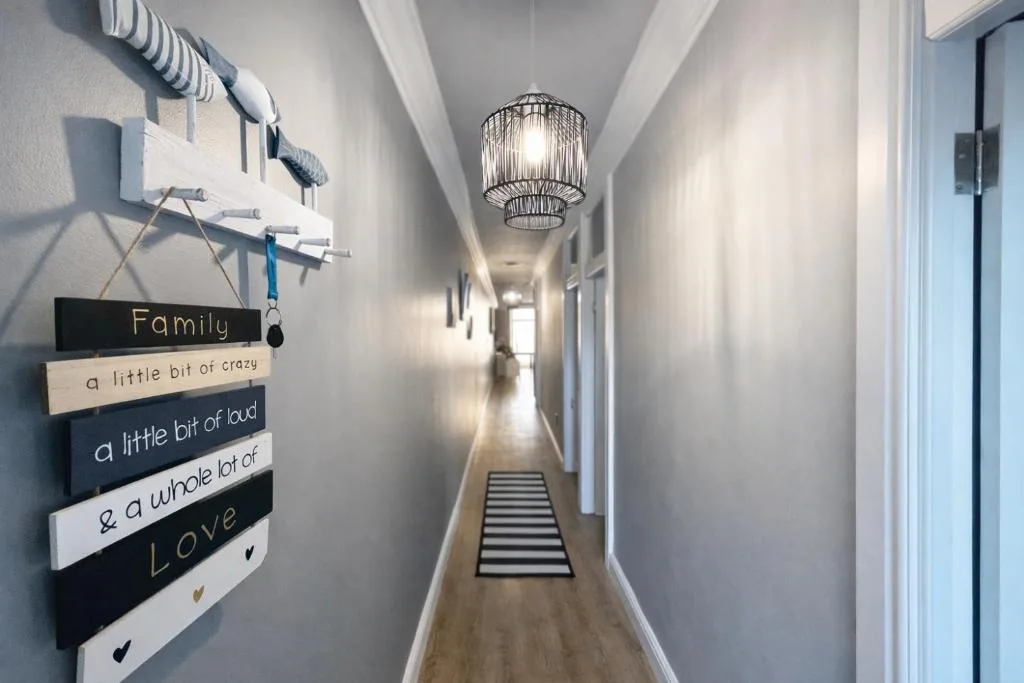 Bright hallway with decorative family sign and pendant lighting fixture