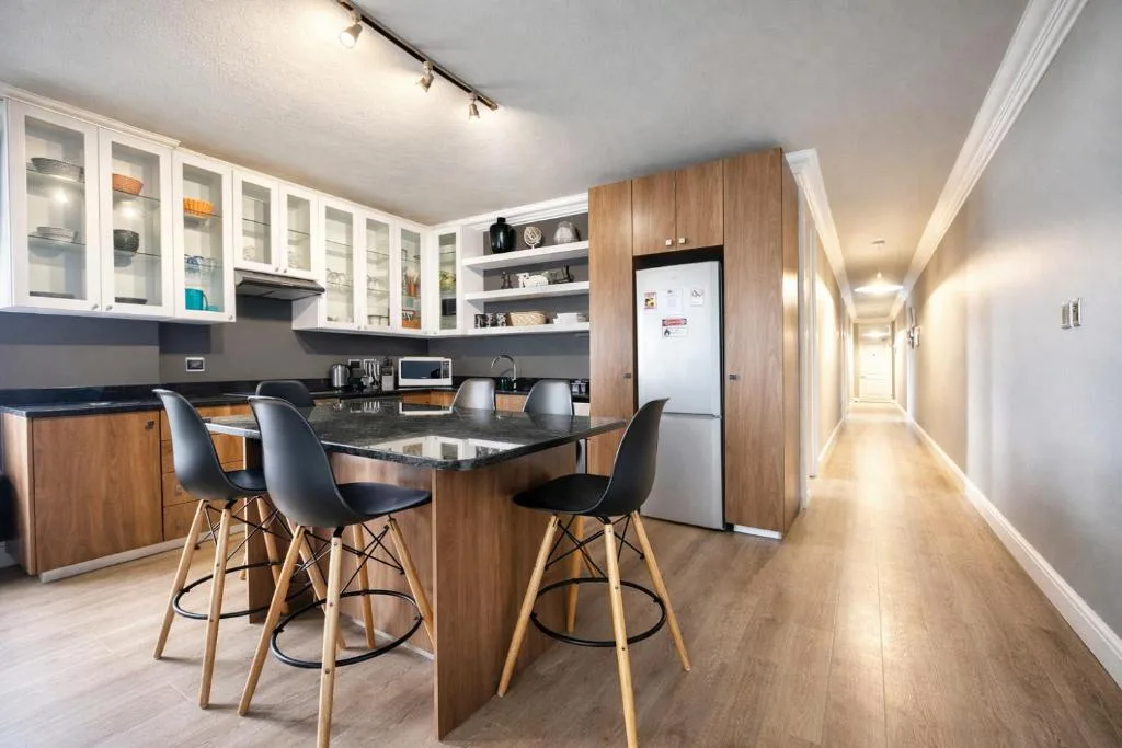 Modern kitchen with island seating, white cabinetry, and stainless steel appliances