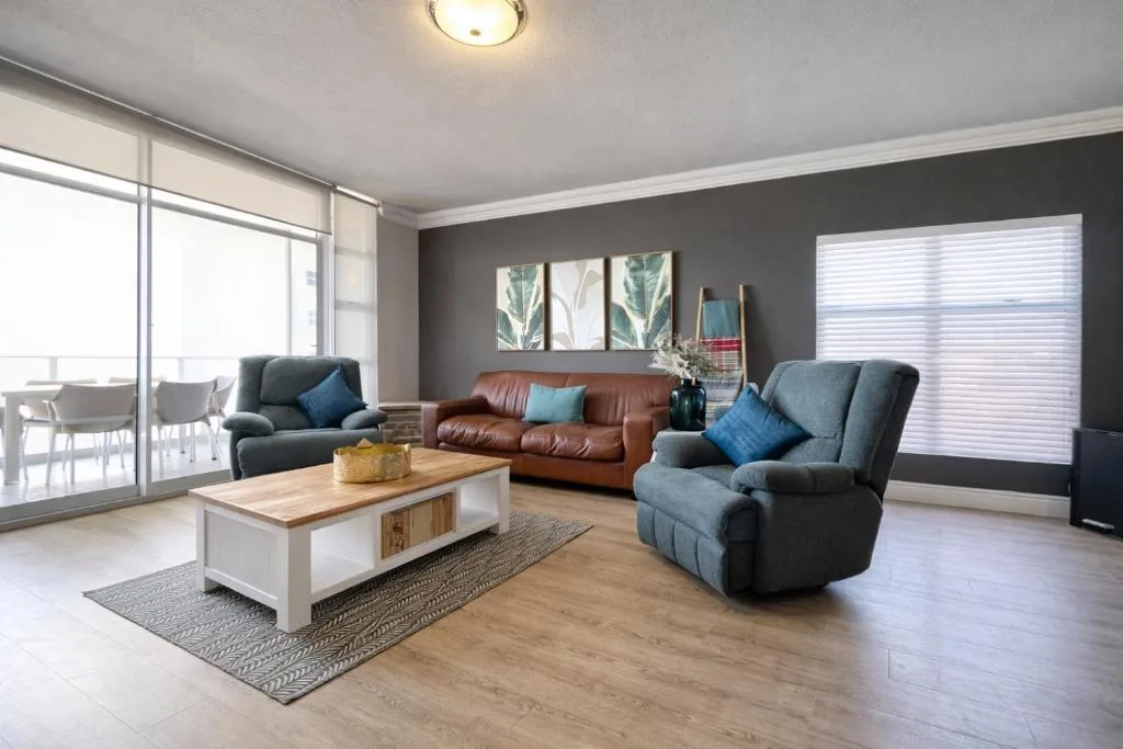Modern living room with comfortable seating and large windows overlooking the ocean