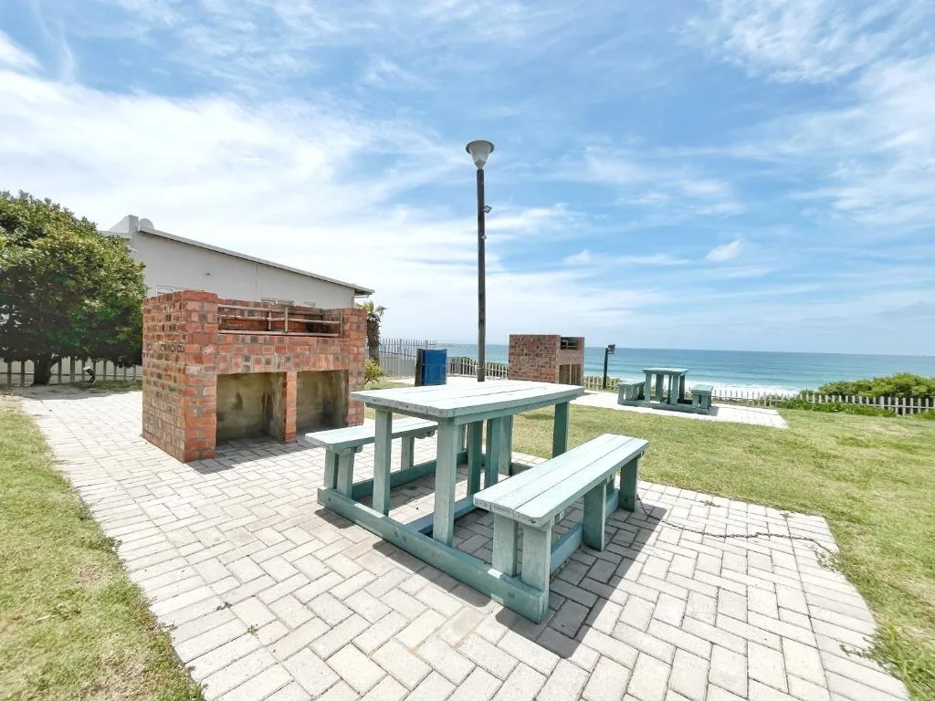 Beachfront patio with picnic table and brick braai overlooking ocean