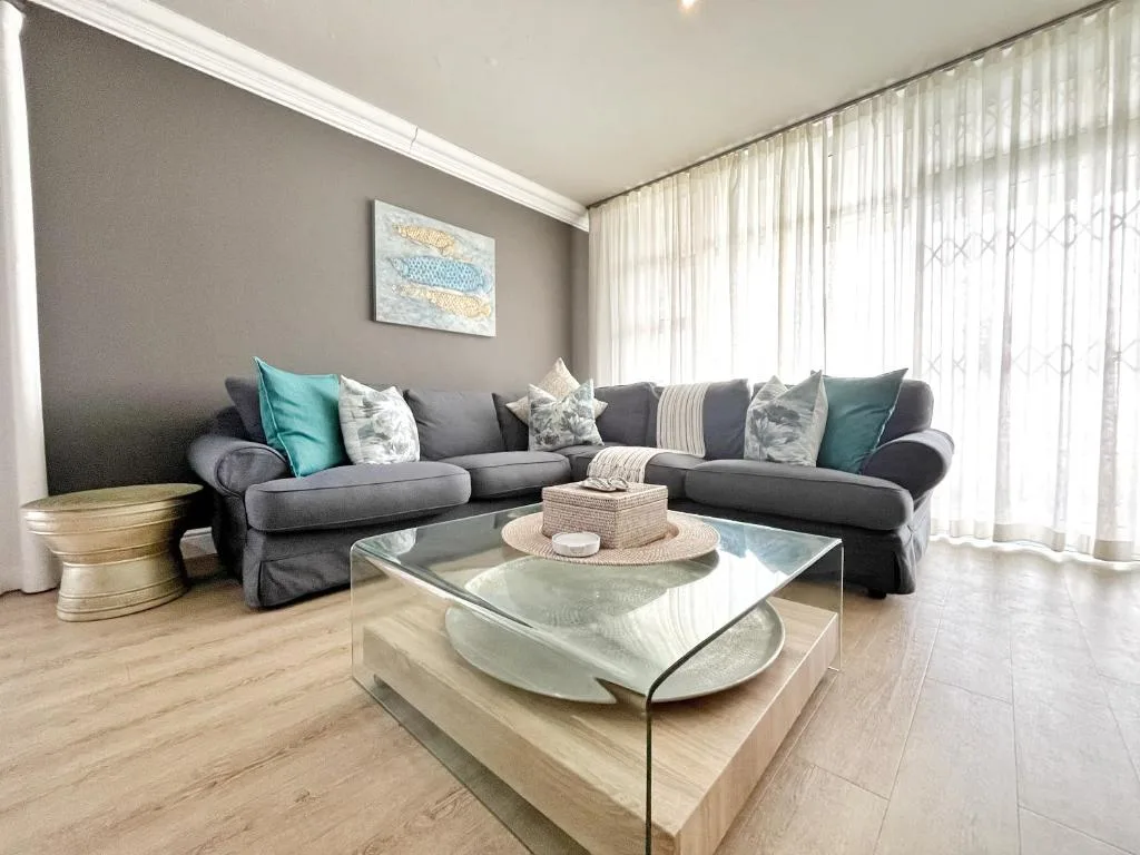 Modern lounge with gray sectional sofa and glass coffee table