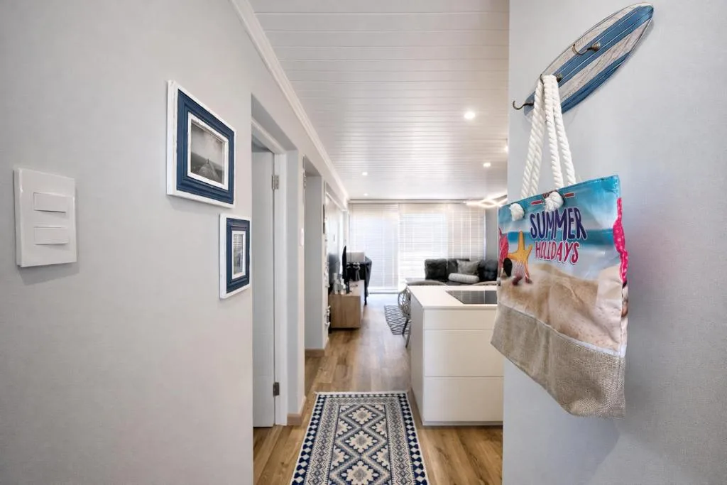 Bright hallway with nautical decor, framed artwork, and beach-themed accessories