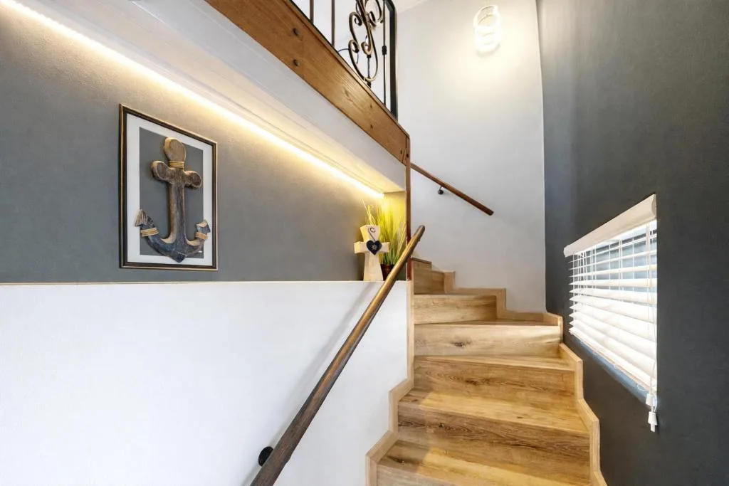 Modern staircase with wooden steps and nautical decor artwork