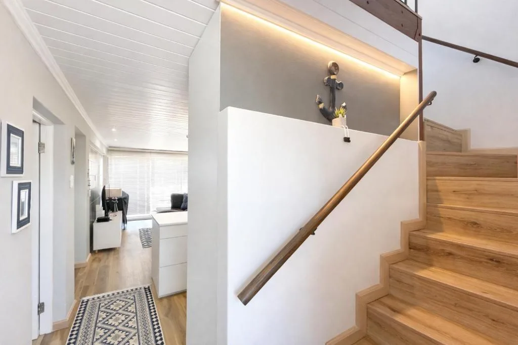 Modern staircase with wooden steps and nautical anchor wall decor