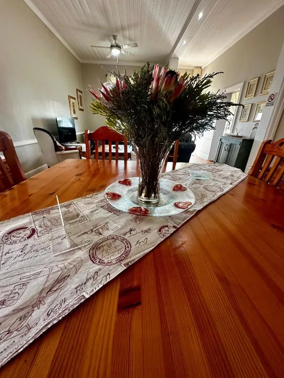 Wooden dining table with floral centerpiece and decorative runner