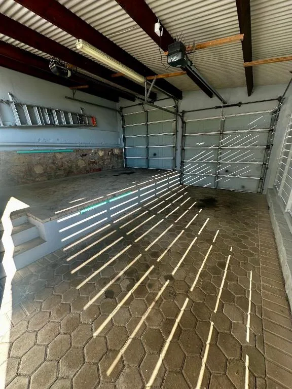 Empty garage interior with corrugated metal roof and open doors