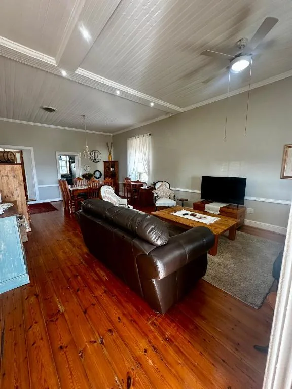 Spacious living room with brown leather sofa and flat-screen television