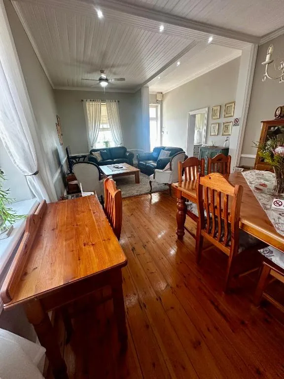 Open-plan lounge and dining area with wooden furniture and blue sofa