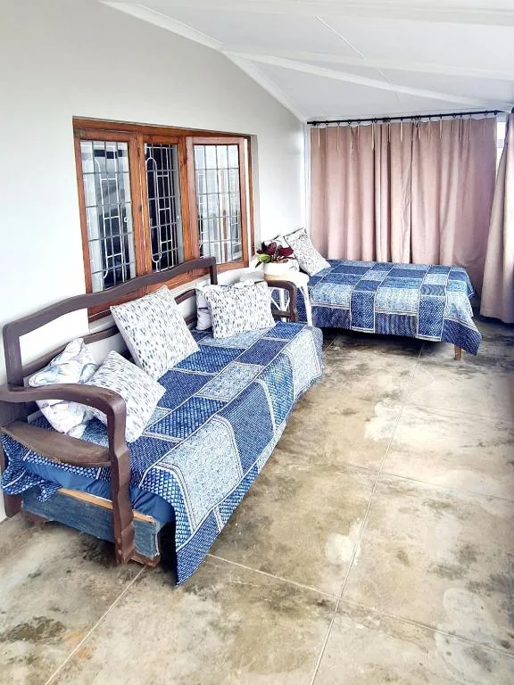 Bright bedroom with two single beds, wooden furniture, and patio doors