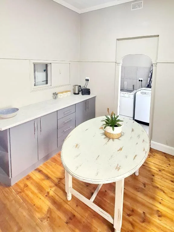 Modern kitchen with gray cabinetry, white countertop, and dining table
