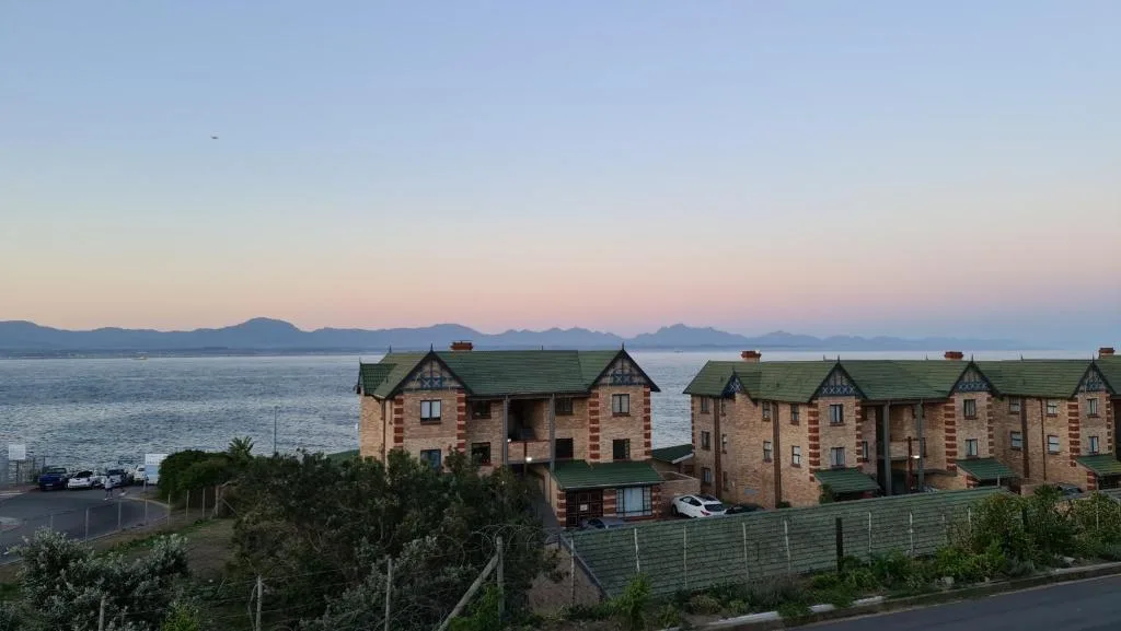Waterfront property with mountains visible across the bay at sunset