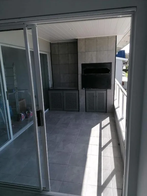 Covered patio area with TV mounted on wall and tiled flooring