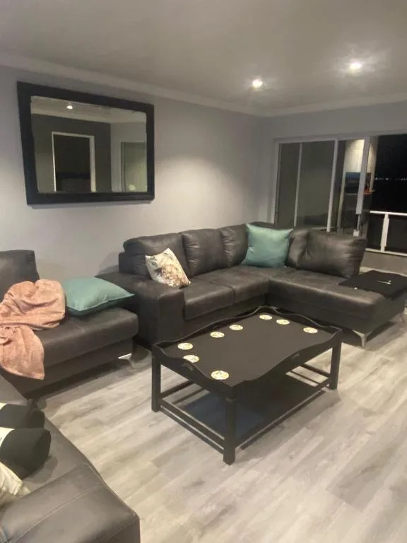 Modern lounge with black leather sectional sofa and coffee table