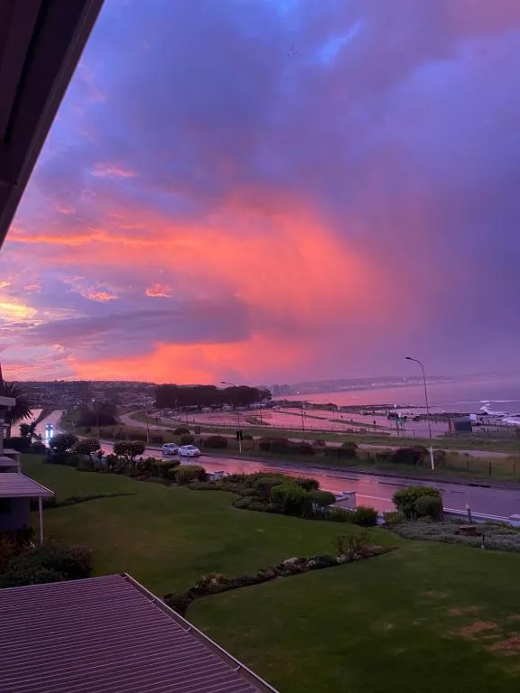 Dramatic sunset over lagoon with vibrant pink and purple sky