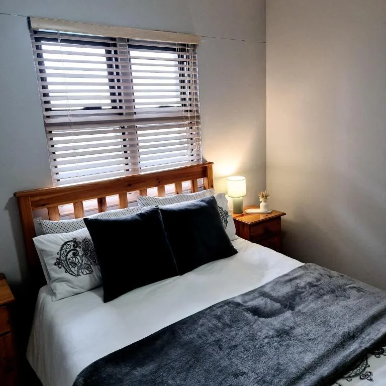 Cozy bedroom with wooden bed frame and black accent pillows