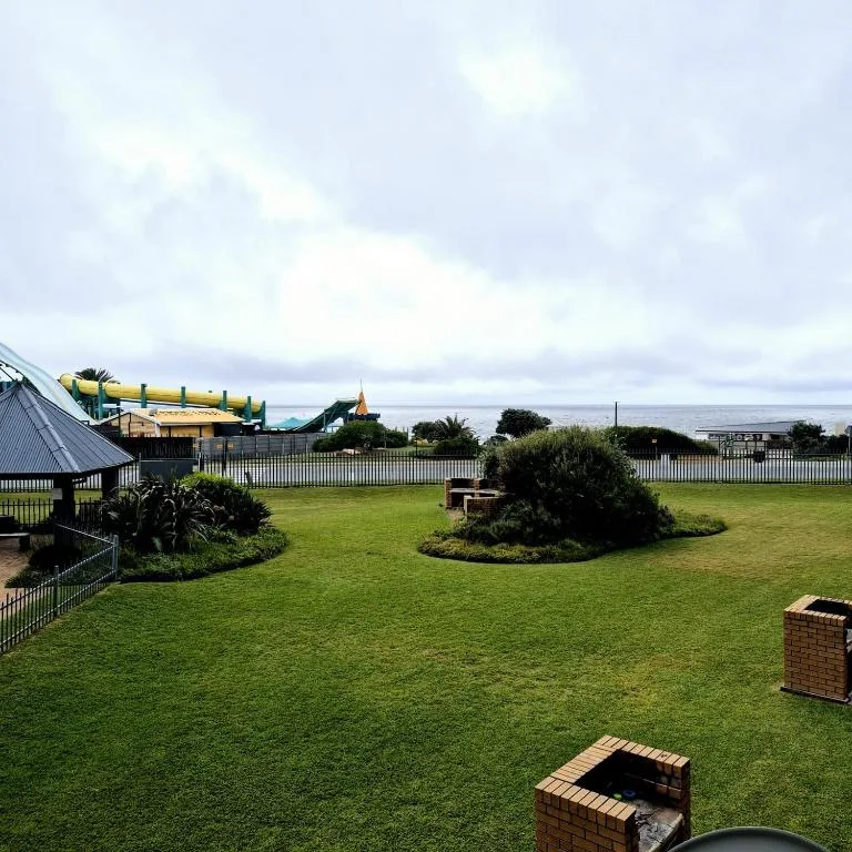 Spacious manicured lawn with braai areas and fenced gardens overlooking countryside