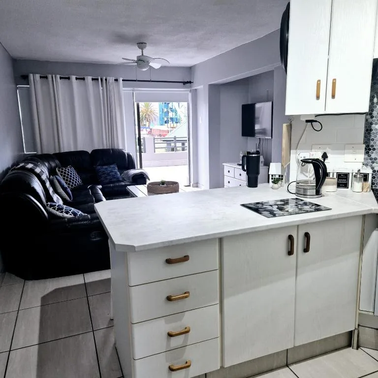 Modern white kitchen with island counter overlooking living area with sofa