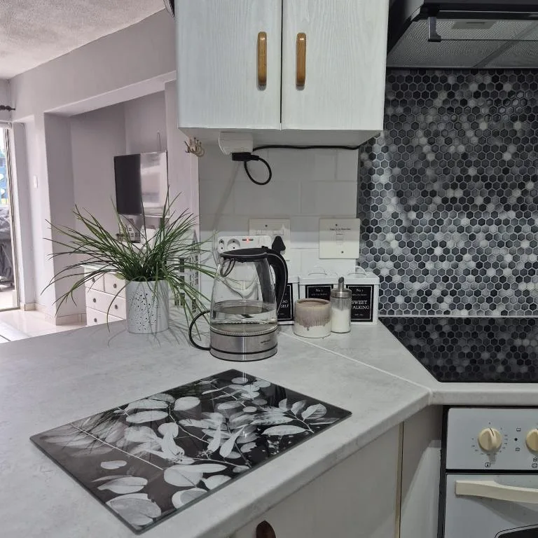 Modern kitchen with white cabinetry, hexagonal tile backsplash, and countertop details