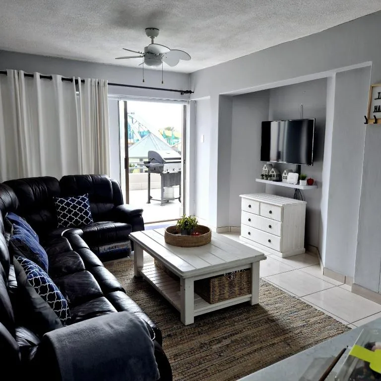 Modern living room with black leather sofas and wall-mounted TV