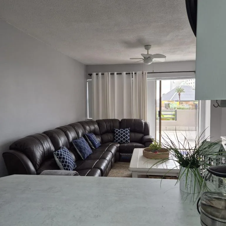Modern lounge with black leather sectional sofa and sliding doors to deck