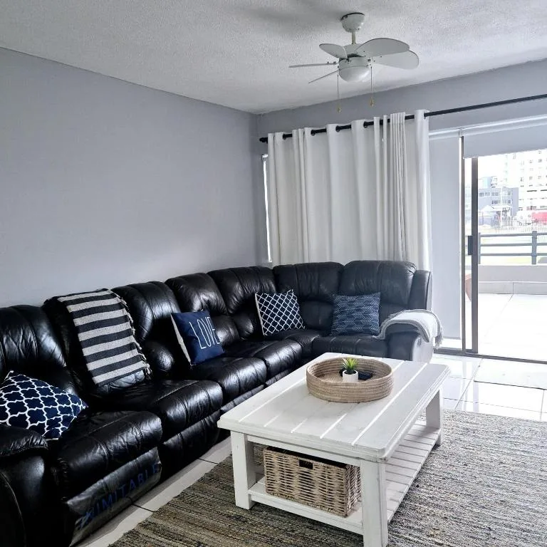 Modern lounge with black leather sectional sofa and white coffee table