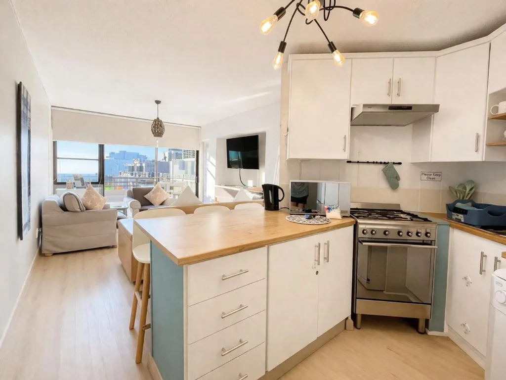 Modern kitchen with island, stove, and city views beyond