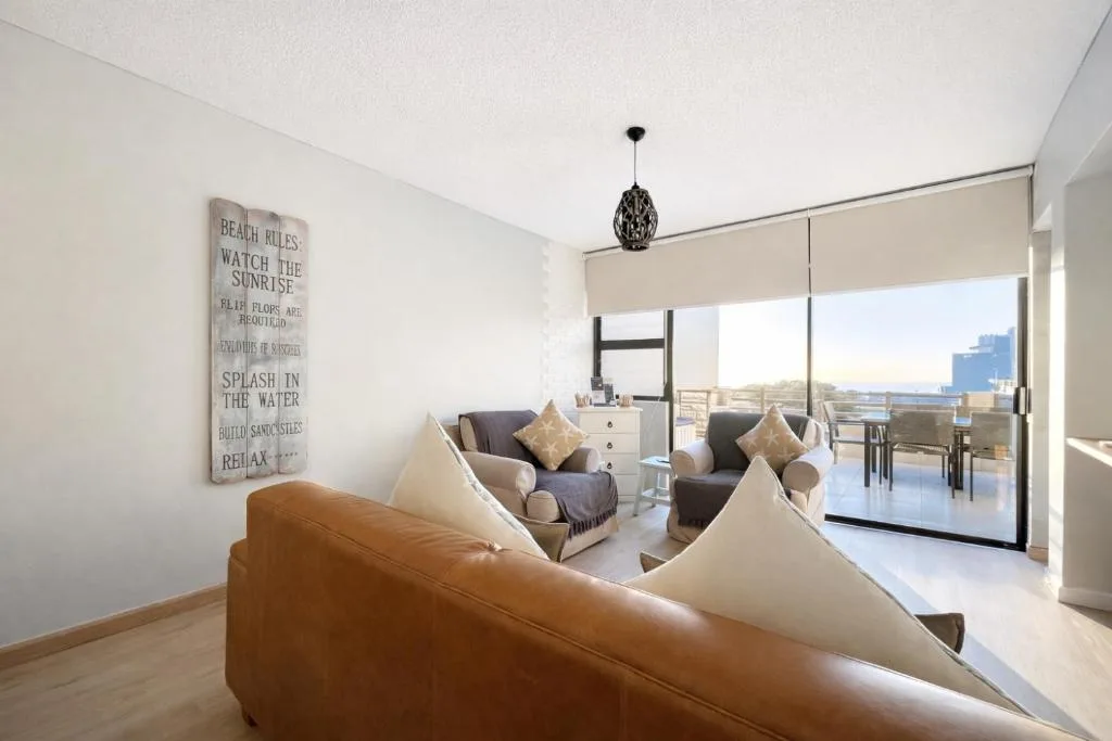 Modern lounge with leather sofa and ocean view through large sliding doors