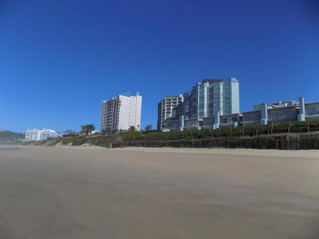 Beachfront apartment buildings with sandy beach and clear blue sky